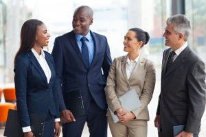 Photo of four business people talking and smiling